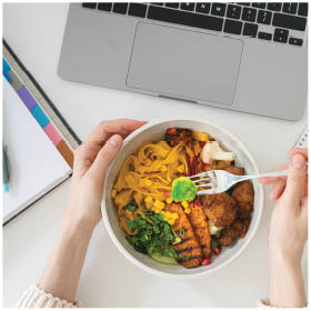 Woman eating vegan lunch at the desk at work
