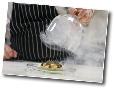 Chef's hand lifts up glass cloche from a plate with hot food and moving smoke at the restaurant. Exquisite dish, creative restaurant meal concept, haute couture food.