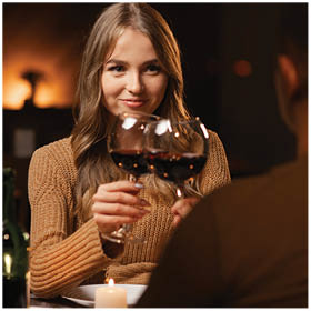Happy young couple in love drinking wine having romantic dinner, celebrating Valentines Day at home. Valentine's Day concept. Copy space