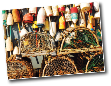 A pier in New England is populated with wooden vintage lobster traps and colorful lobster buoys from the local fishermen and trappers
