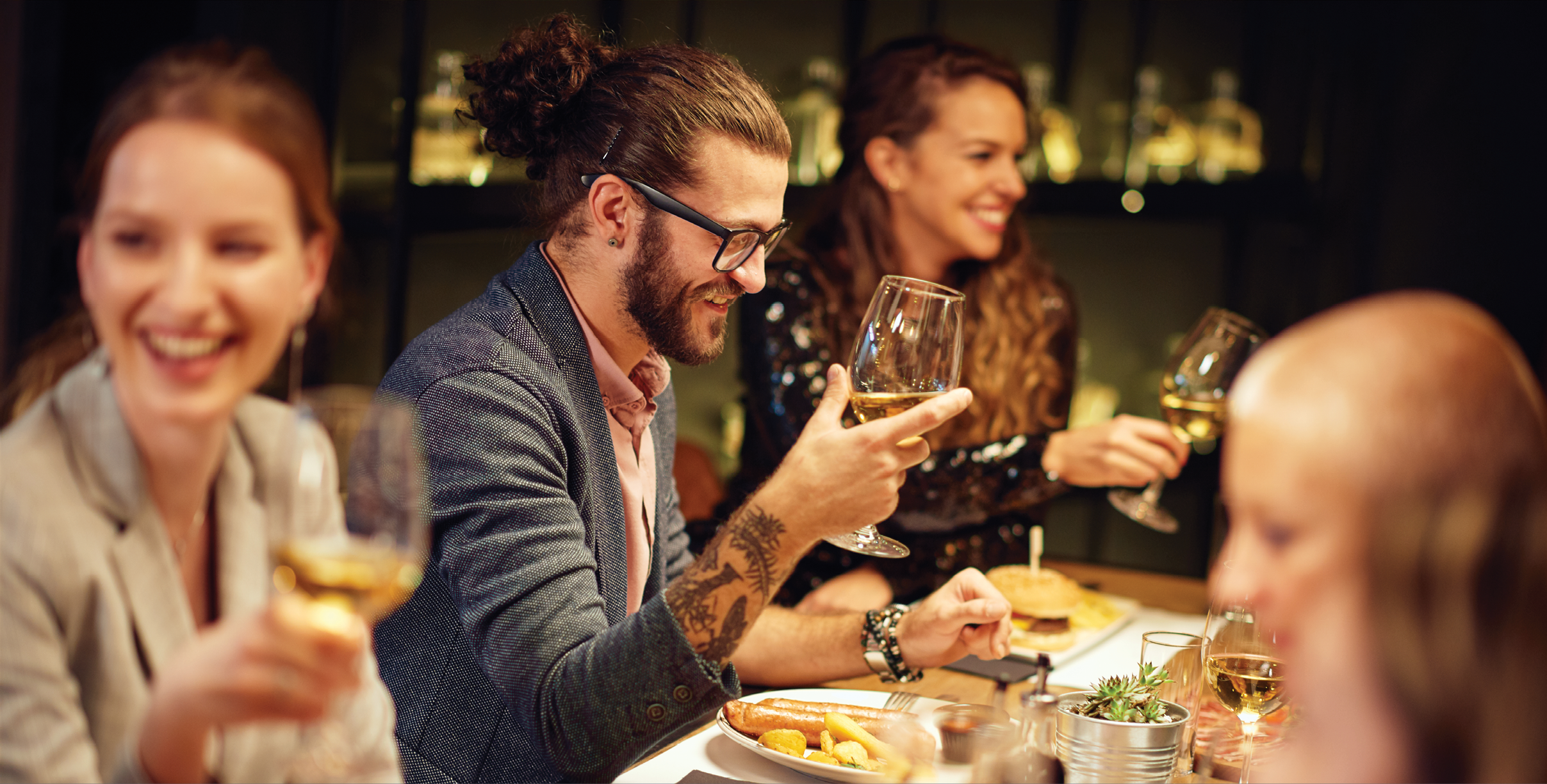 Group of best friends sitting in restaurant, having dinner, drinking wine and having fun.